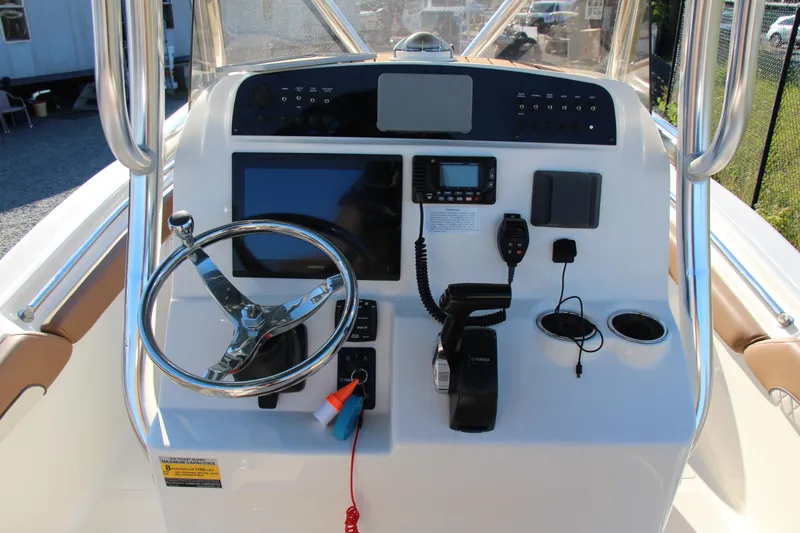 Slide: The Image of 2022 Pioneer 222 Islander boat dashboard with steering wheel and navigation controls. - 8