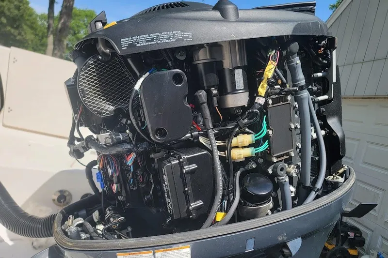 Slide: The Image of Close-up of a 2016 Robalo R227 Dual Console boat engine, showcasing intricate wiring and components. - 10