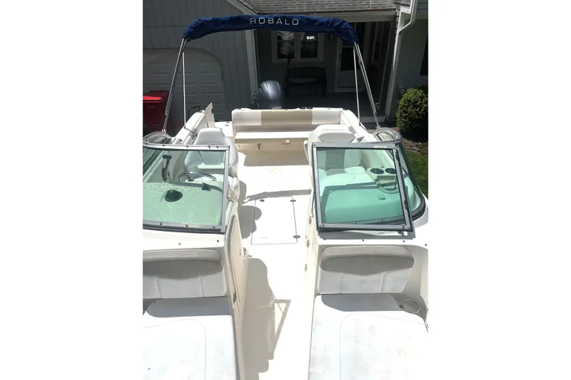 Slide: The Image of 2016 Robalo R227 Dual Console boat with open deck and windshield, parked outdoors. - 11