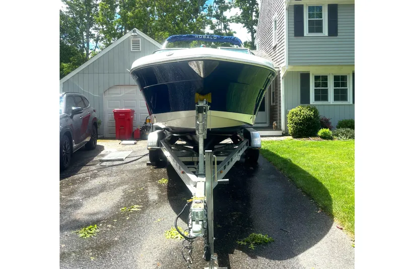 Slide: The Image of 2016 Robalo R227 Dual Console boat on trailer in driveway near house. - 12