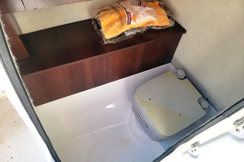 Slide: The Image of Interior of 2016 Robalo R227 Dual Console boat with storage and portable toilet. - 14