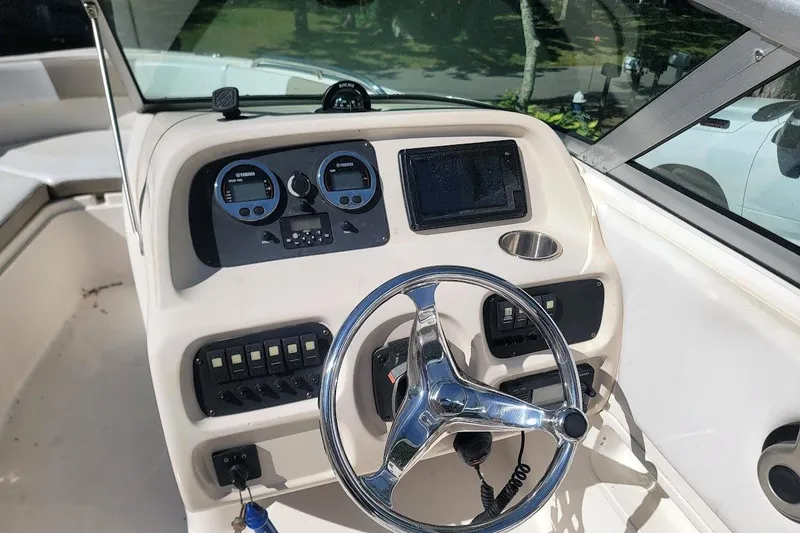 Slide: The Image of 2016 Robalo R227 Dual Console boat dashboard with steering wheel and control panel. - 2