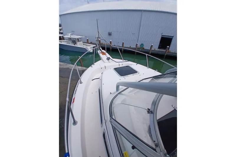 Slide: The Image of 1996 Grady-White Advance 247 boat docked near a large warehouse. - 21