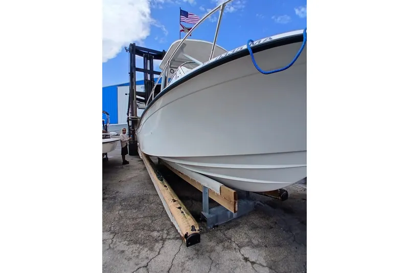 Slide: The Image of 1996 Grady-White Advance 247 boat on a lift, with American flag in background. - 31