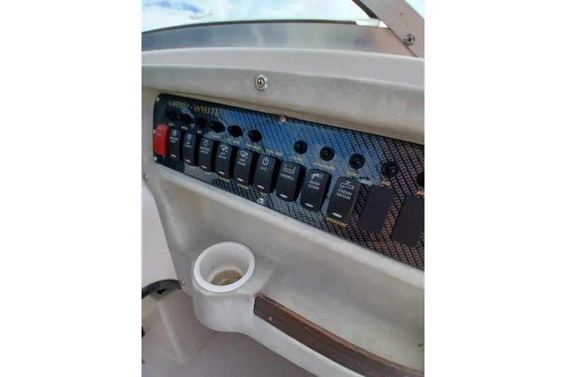 Slide: The Image of Control panel of a 1996 Grady-White Advance 247 boat with switches and cup holder. - 33