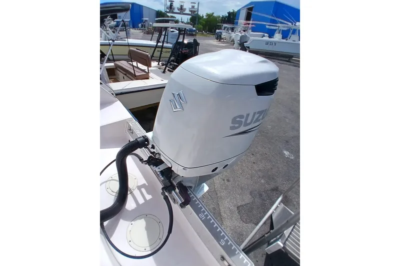 Slide: The Image of Outboard motor on 1996 Grady-White Advance 247 boat, docked near blue buildings. - 41