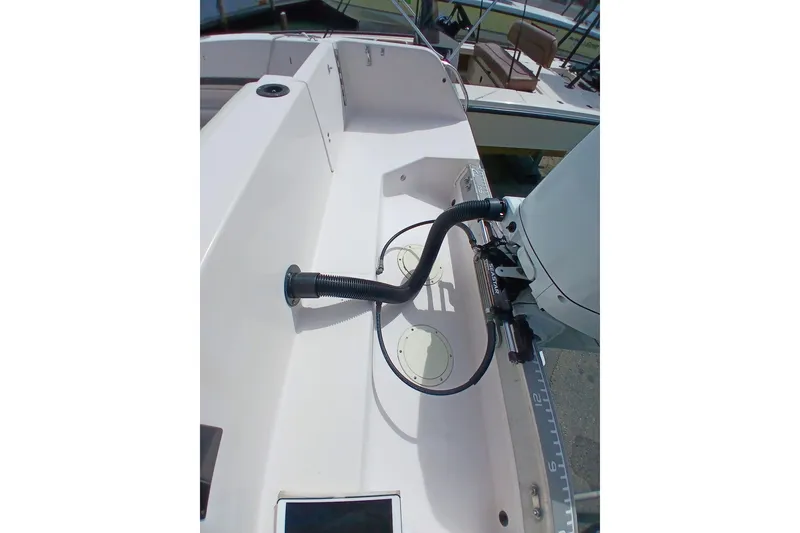 Slide: The Image of 1996 Grady-White Advance 247 boat deck with motor and control cables. - 47