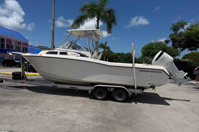 Slide: The Image of 1996 Grady-White Advance 247 boat on trailer, parked outdoors under clear sky. - 5