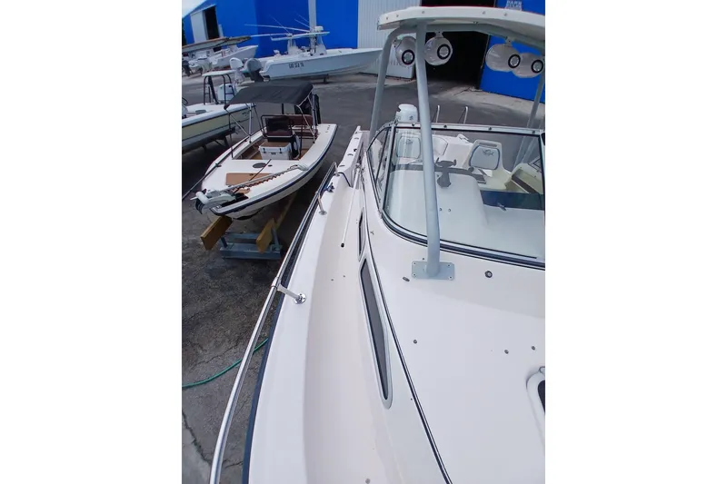 Slide: The Image of 1996 Grady-White Advance 247 boat docked near blue building, showcasing sleek design. - 8