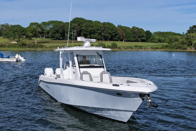 Slide: The Image of 2022 Everglades 365 Center Console boat cruising on a scenic lake. - 10