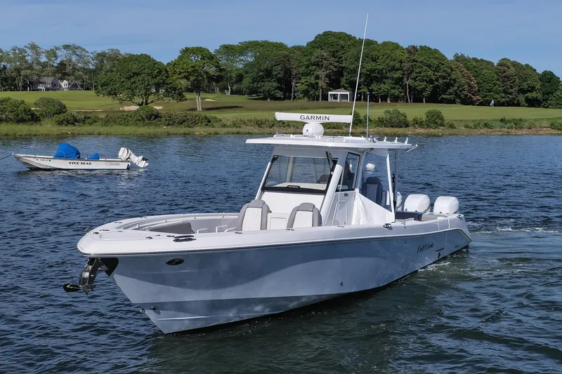 Slide: The Image of 2022 Everglades 365 Center Console boat cruising on a scenic lake. - 12