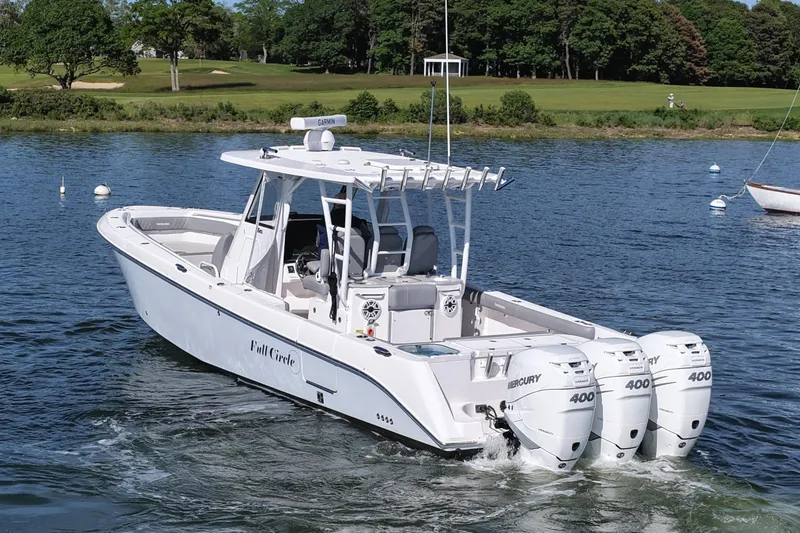 Slide: The Image of 2022 Everglades 365 Center Console boat with triple Mercury 400 engines on a scenic lake. - 2
