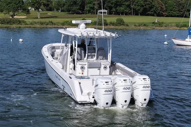 Slide: The Image of 2022 Everglades 365 Center Console boat with triple Mercury 400 engines on a serene lake. - 3