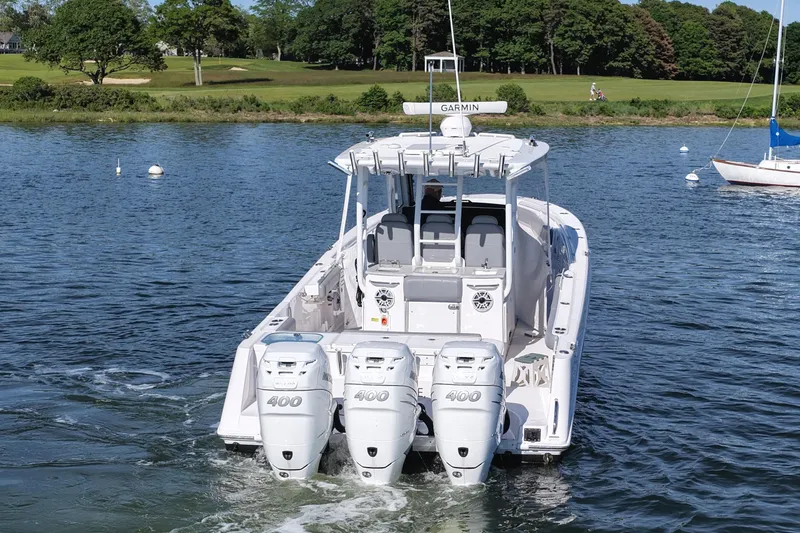Slide: The Image of 2022 Everglades 365 Center Console boat with triple 400 engines on a serene lake. - 5