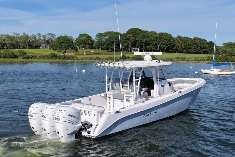 Slide: The Image of 2022 Everglades 365 Center Console boat with triple Mercury engines on a scenic lake. - 6