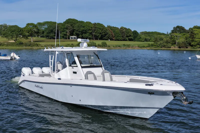 Slide: The Image of 2022 Everglades 365 Center Console boat cruising on a scenic lake with lush greenery. - 9