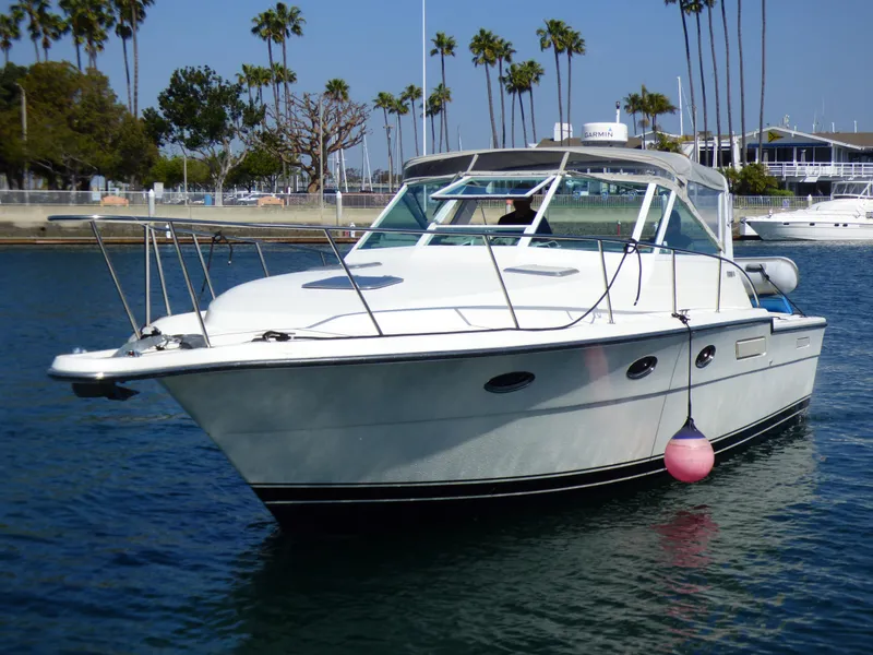 Slide: The Image of A 1989 Tiara Yachts 3300 Open is on the water, surrounded by palm trees. - 2