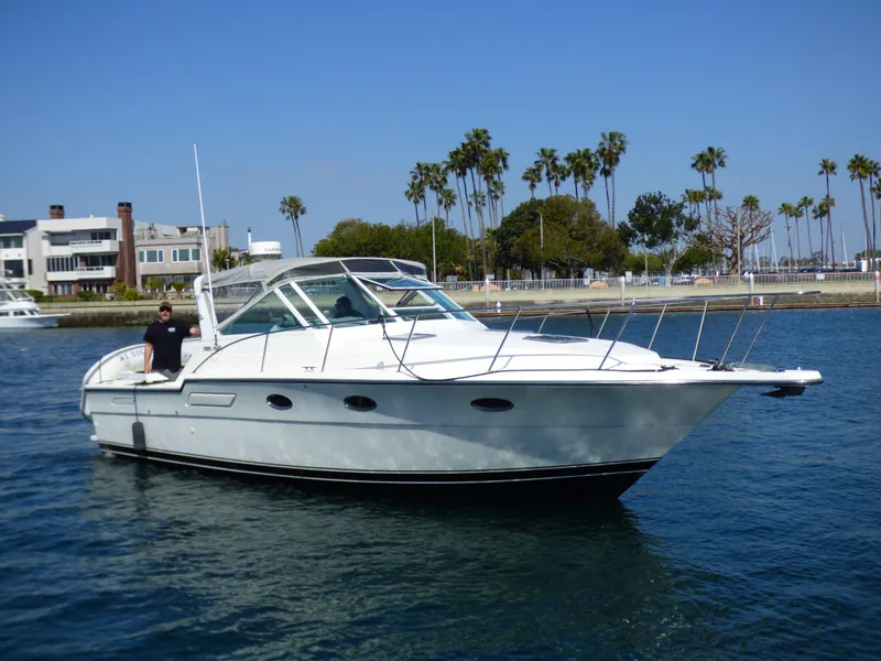 Slide: The Image of A 1989 Tiara Yachts 3300 Open cruising on calm water, surrounded by palm trees. - 36