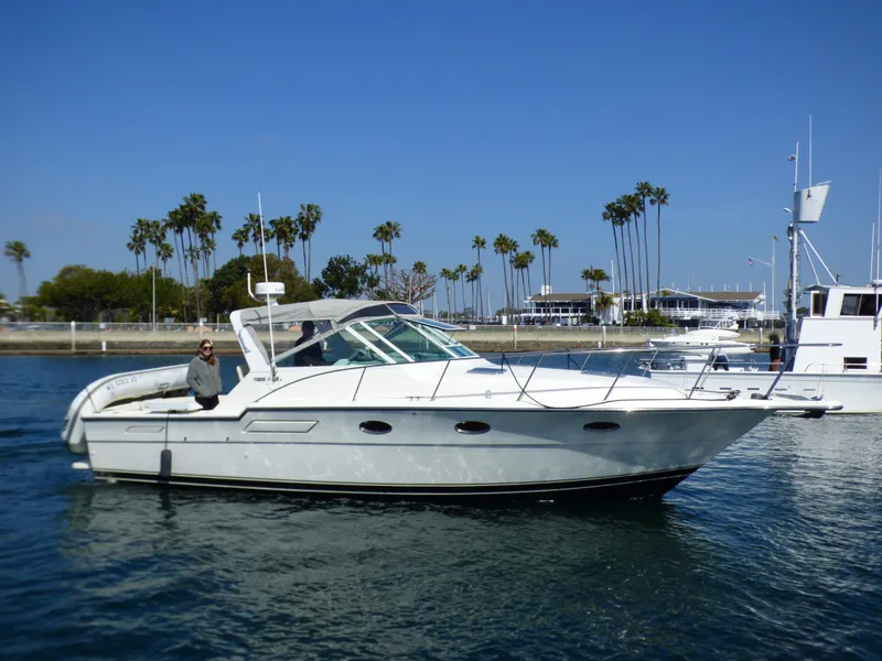 Slide: The Image of A white motorboat cruising on calm water, with palm trees in the background. - 37