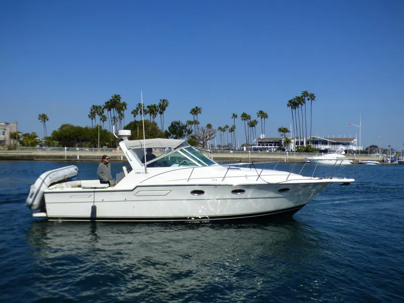 Slide: The Image of A 1989 Tiara Yachts 3300 Open cruising on calm water with palm trees in the background. - 38