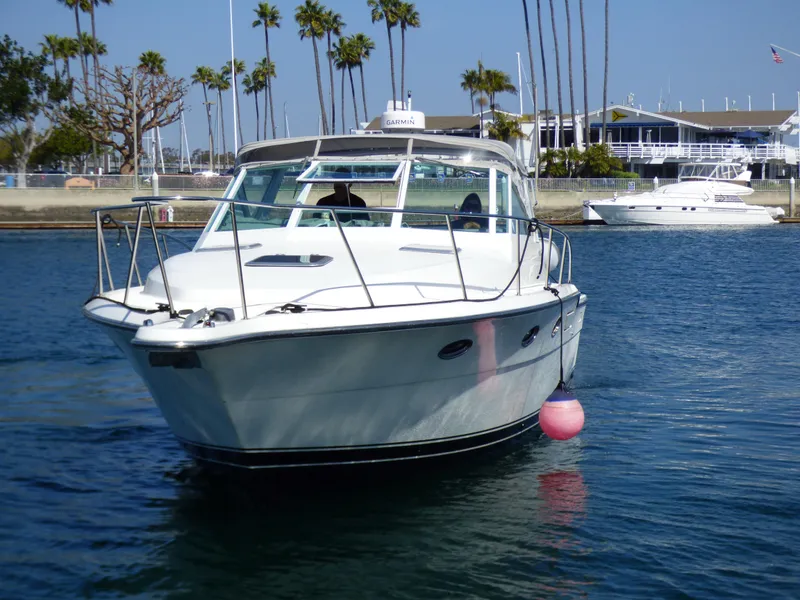 Slide: The Image of A 1989 Tiara Yachts 3300 Open cruising on calm water. Palm trees in the background. - 39