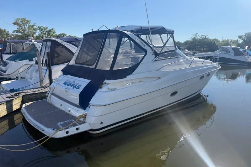 The Image of 2005 Regal Commodore 3560 IO boat docked in a marina under clear skies. - 0