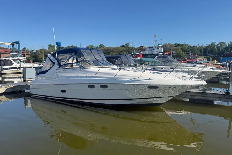 The Image of 2005 Regal Commodore 3560 IO yacht docked at marina under clear blue sky. - 2