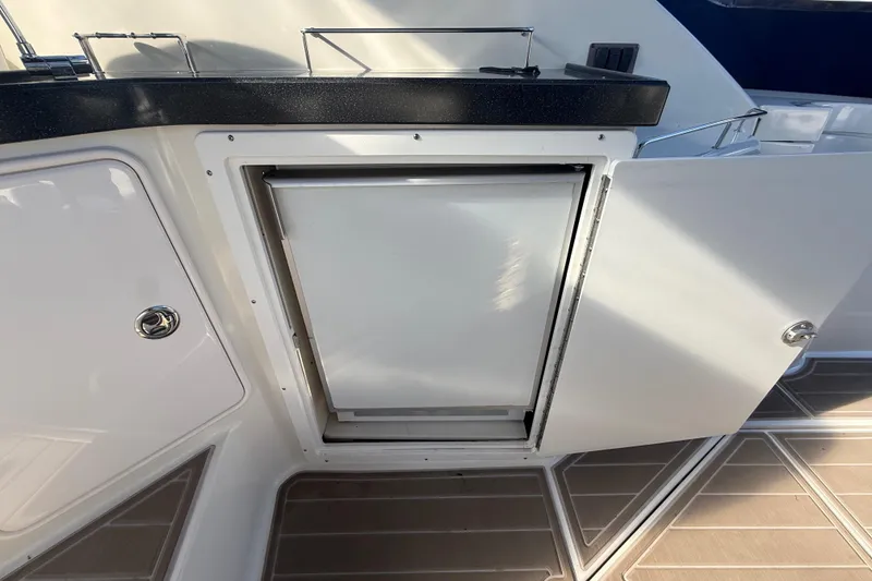 Slide: The Image of 2005 Regal Commodore 3560 IO boat interior with open cabinet and countertop. - 21