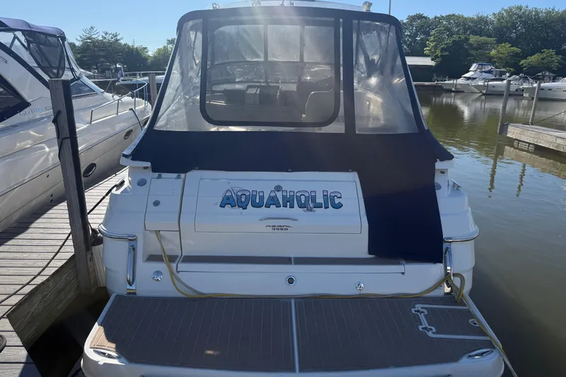 Slide: The Image of 2005 Regal Commodore 3560 IO boat docked, featuring "Aquaholic" name on the stern. - 3