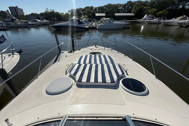 Slide: The Image of 2005 Regal Commodore 3560 IO yacht docked at marina with striped sun pad. - 43