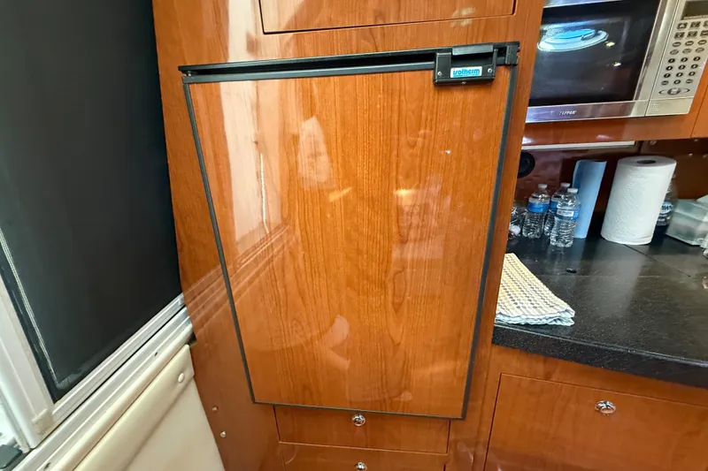 Slide: The Image of Wood-paneled refrigerator in 2005 Regal Commodore 3560 IO yacht kitchen. - 51