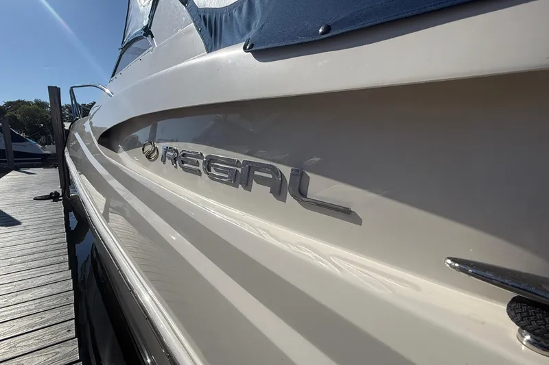 Slide: The Image of 2005 Regal Commodore 3560 IO boat docked, showcasing sleek design and branding. - 6