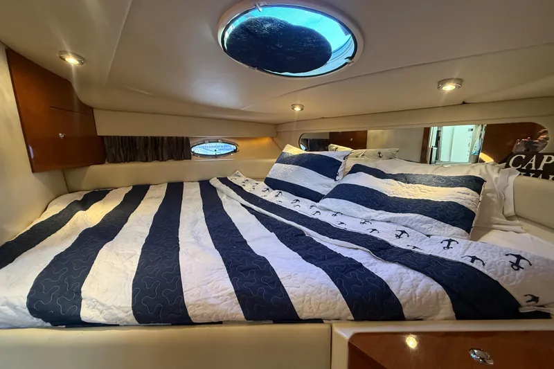 Slide: The Image of Luxurious cabin interior of 2005 Regal Commodore 3560 IO yacht with striped bedding. - 64