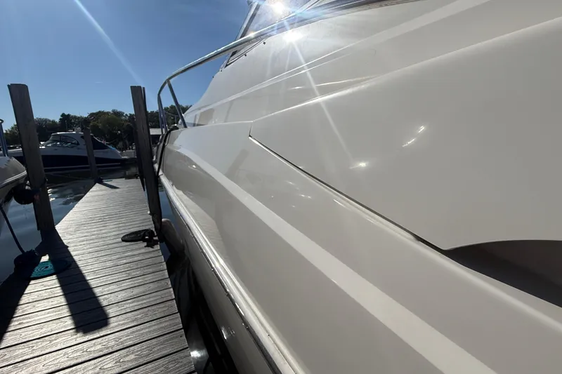 Slide: The Image of 2005 Regal Commodore 3560 IO yacht docked under bright sunlight. - 7