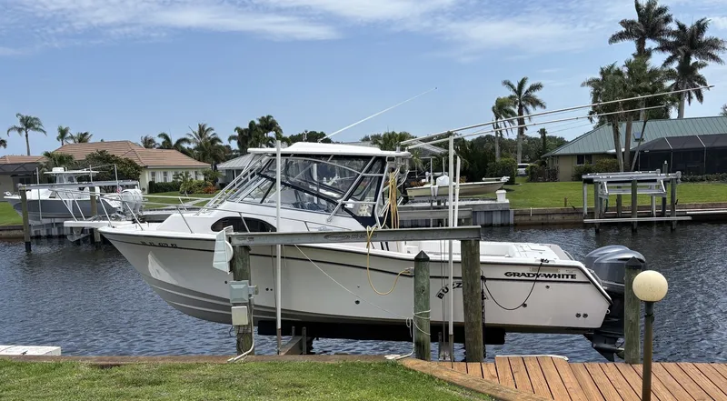 The Image of 2004 Grady-White Marlin 300 boat docked, surrounded by palm trees. - 1