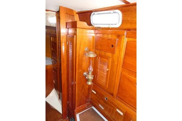 Slide: The Image of Interior of a 1978 Tartan 37 sailboat featuring polished wooden cabinetry and brass fixtures. - 10