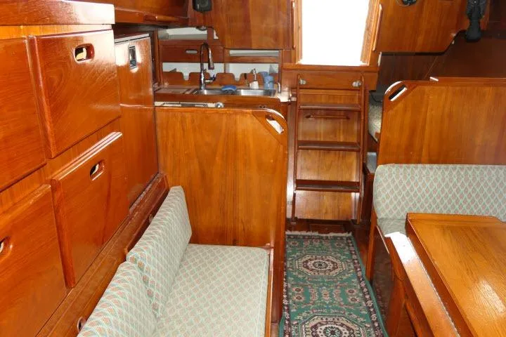 Slide: The Image of Interior of a 1978 Tartan 37 sailboat with wooden cabinetry and patterned seating. - 11