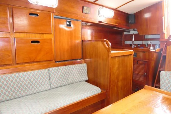 Slide: The Image of Interior of a 1978 Tartan 37 sailboat with wooden cabinetry and cushioned seating. - 12