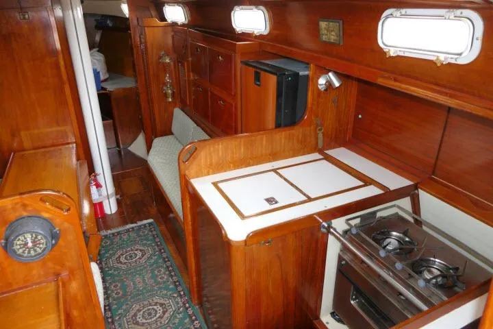 Slide: The Image of Interior of a 1978 Tartan 37 sailboat with wooden cabinetry and compact kitchen area. - 13