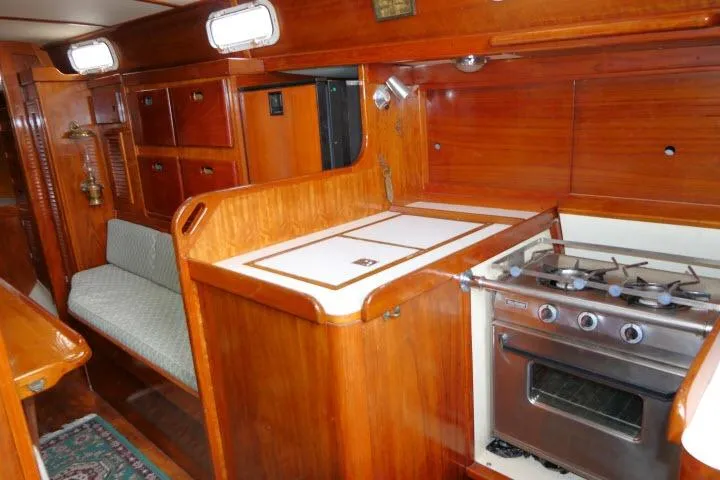 Slide: The Image of Interior of a 1978 Tartan 37 sailboat featuring a wooden galley with stove and seating. - 14