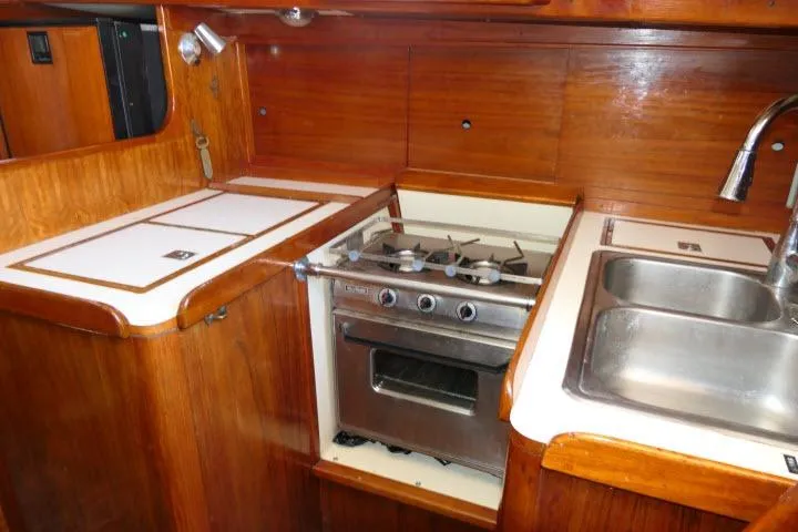 Slide: The Image of 1978 Tartan 37 yacht kitchen with stove, sink, and wooden cabinetry. - 15