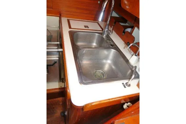 Slide: The Image of 1978 Tartan 37 yacht kitchen with dual stainless steel sinks and wooden cabinetry. - 18