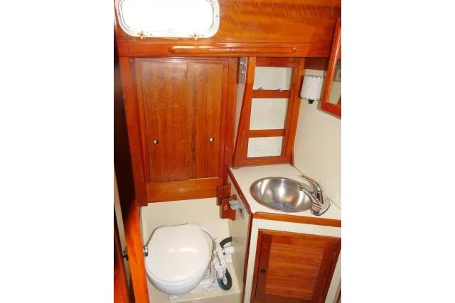 Slide: The Image of 1978 Tartan 37 yacht bathroom with wooden cabinetry, stainless steel sink, and marine toilet. - 25