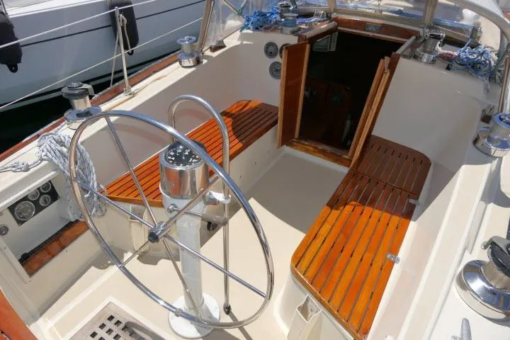 Slide: The Image of Cockpit of a 1978 Tartan 37 sailboat with wooden seating and a large steering wheel. - 30