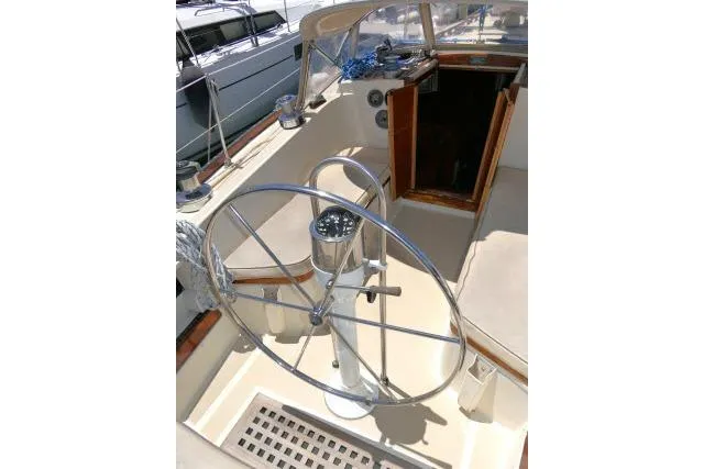 Slide: The Image of 1978 Tartan 37 sailboat cockpit with steering wheel and open cabin entrance. - 31
