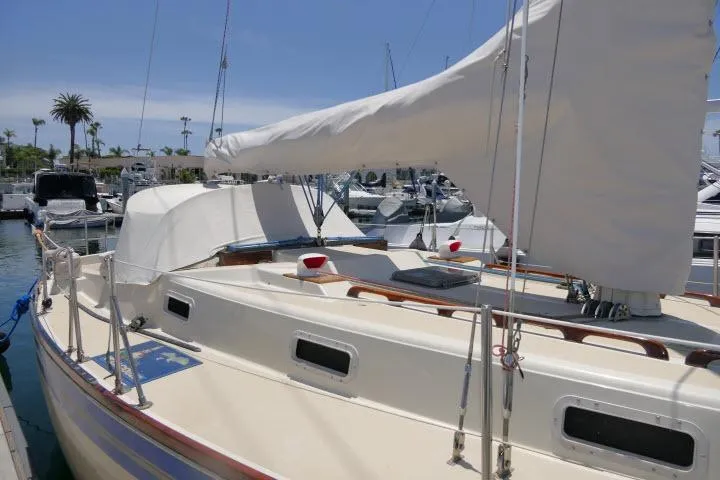 Slide: The Image of 1978 Tartan 37 sailboat docked in a marina, featuring a covered mainsail and classic design. - 39