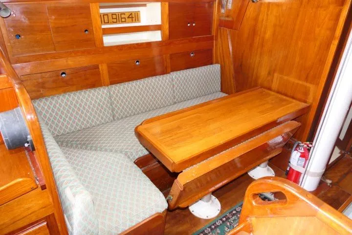 Slide: The Image of Interior of a 1978 Tartan 37 sailboat with wooden table and cushioned seating. - 4