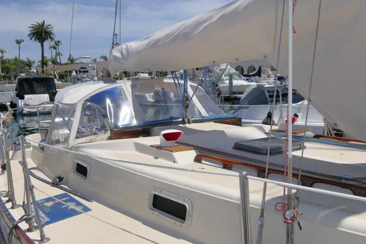Slide: The Image of 1978 Tartan 37 sailboat docked at marina, featuring a spacious deck and clear canopy. - 42