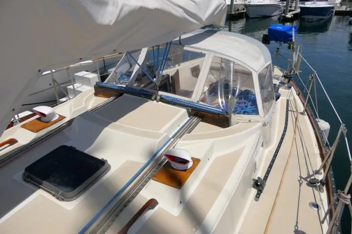 Slide: The Image of 1978 Tartan 37 sailboat with covered cockpit, docked at marina. - 43