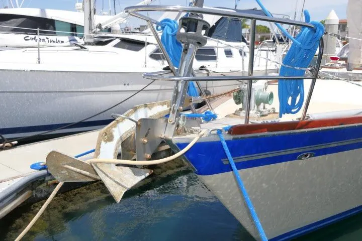 Slide: The Image of 1978 Tartan 37 sailboat with anchor and blue trim docked in marina. - 46